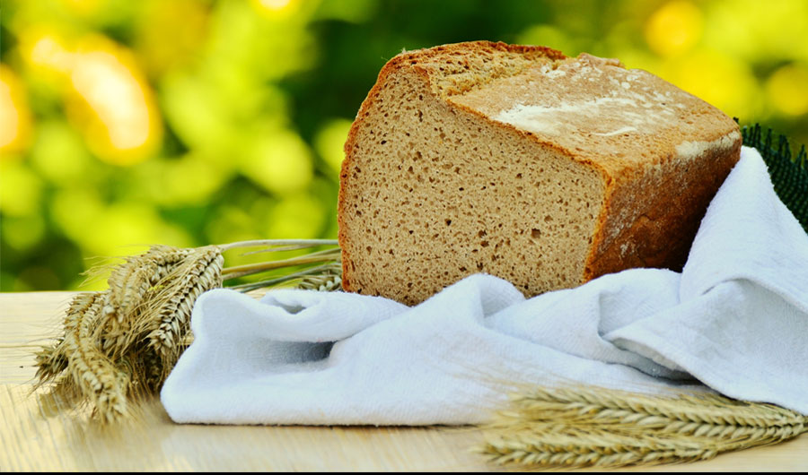 Loaf of whole wheat bread on cloth napkin.