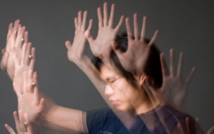 Blurred image of man moving raised hands. 