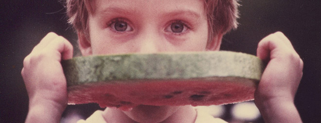 Boy eating large slice of watermelon, cropped. 