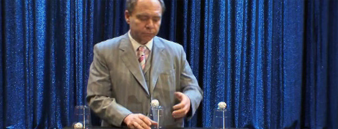 Teller performing cup and ball illusion.