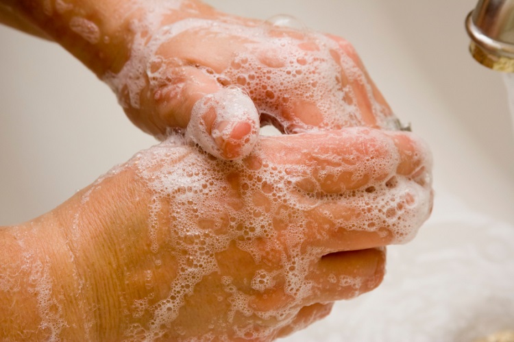 Lathered hands being washed. 