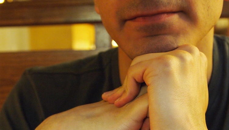 Chin thoughtfully resting on hands. 