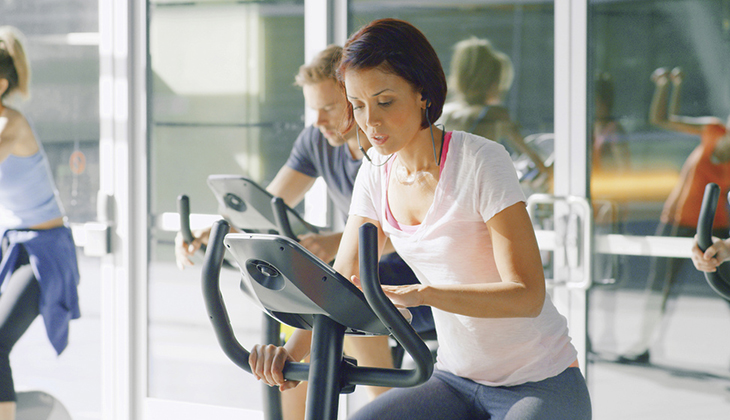 Woman with knitted brow on exercise machine.
