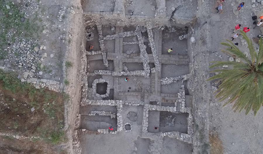 Overhead shot of an archaeological dig at a site known as Megiddo, stone walls bounding several rooms are shown.