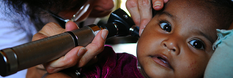 Doctor examining infant's ear. 