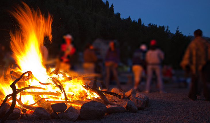 Campfire with people in background.
