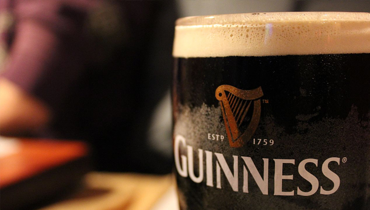 Closeup of pint of Guinness beer with foamy head. 