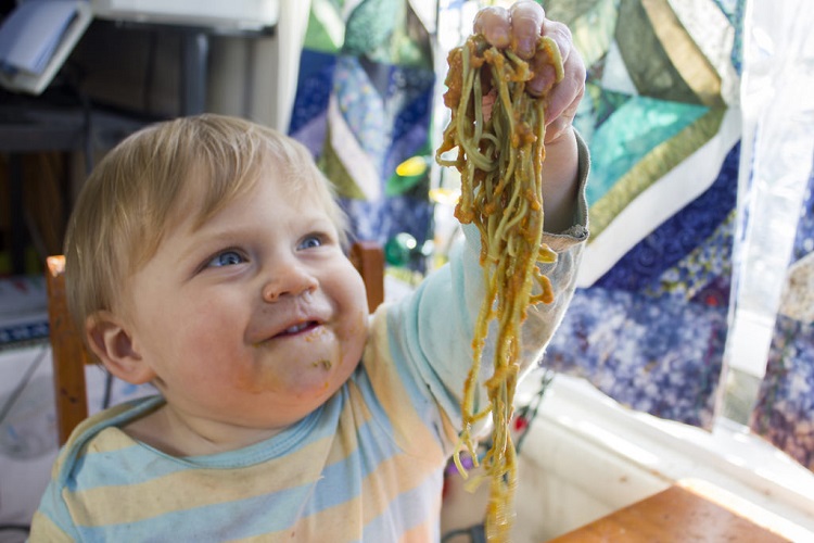 Baby playing with spaghetti. 