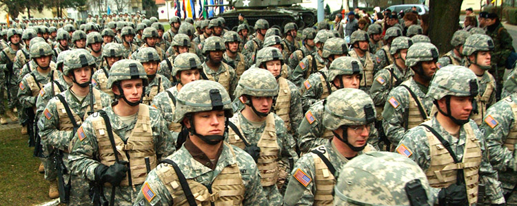 U.S. soldiers in fatigues and helmet standing in formation. 
