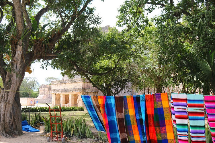 Colorful blankets hanging on a line outdoors. 