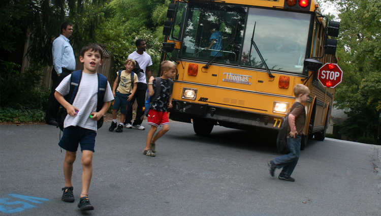 Children walking away from a parked school bus. 