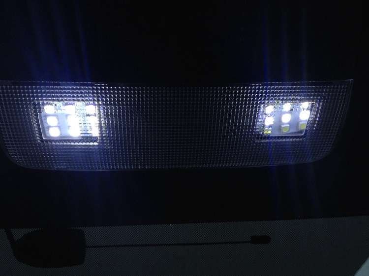 White LED lights in rectangular array aimed down from a dark ceiling. 