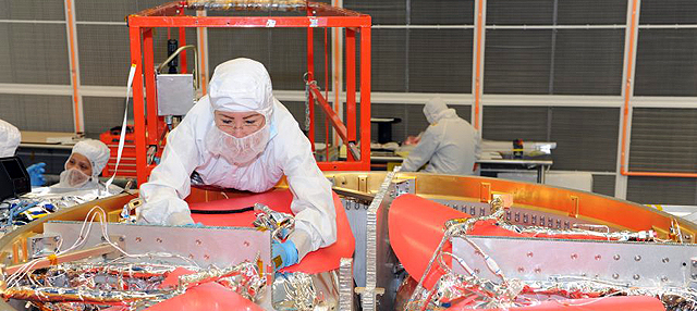 A technician works on a propulsion module for the Magnetospheric Multiscale mission