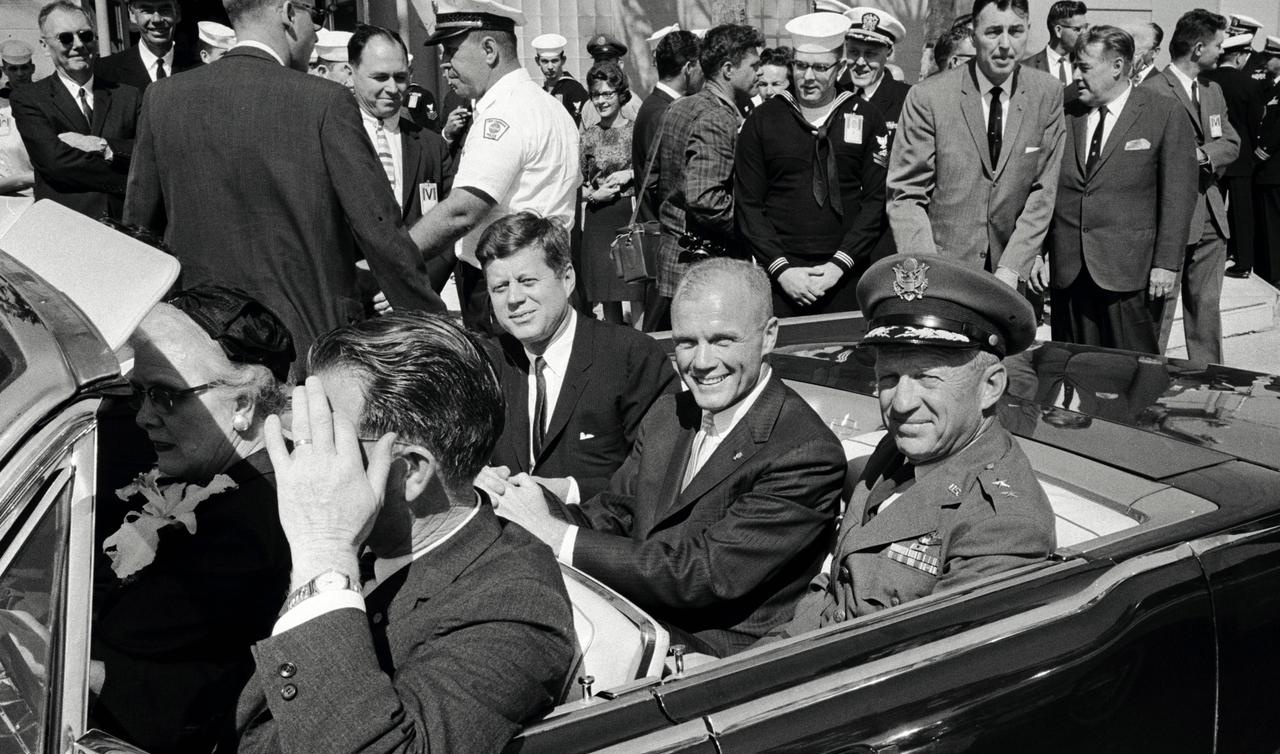 John Glenn rides in the backseat of a car with President John F. Kennedy and General Leighton I. Davis. 