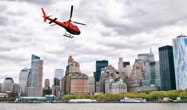 A red helicopter flies over Manhattan.